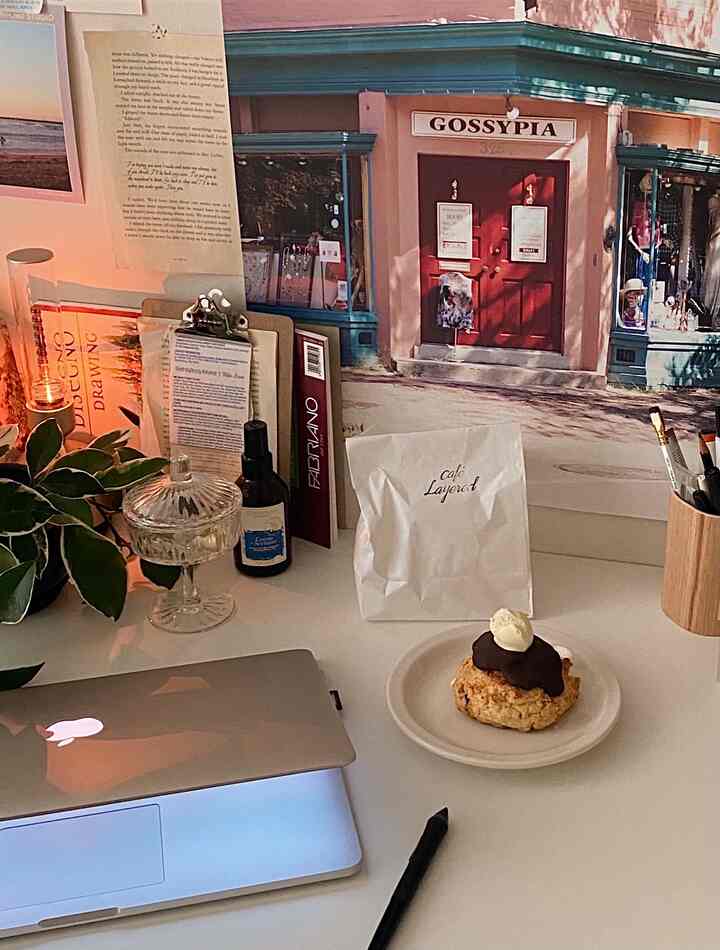 White-toned desk featuring a home cafe vibe with a poster and dessert creating a cozy workspace