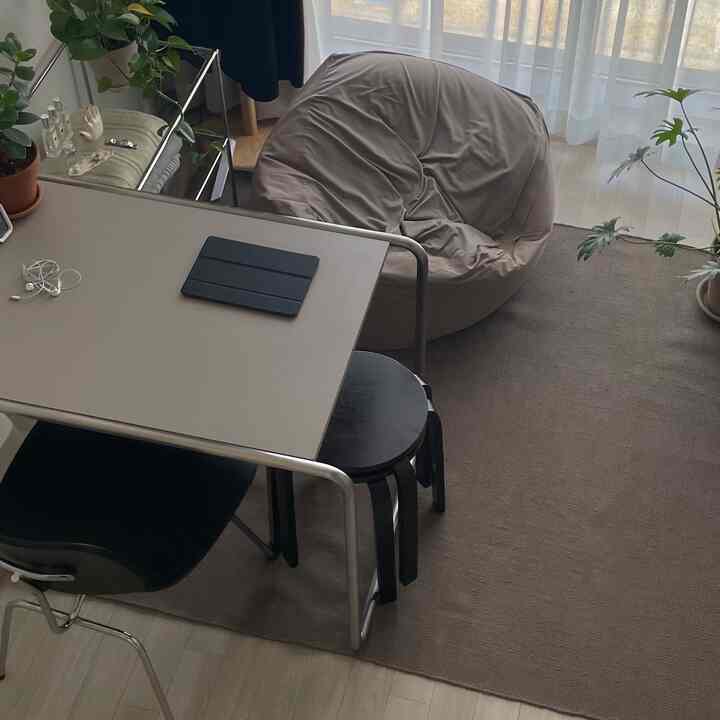 ナチュラルカラーのダイニング、ベージュのビーズクッションとテーブル、観葉植物が配置された雰囲気のあるインテリア