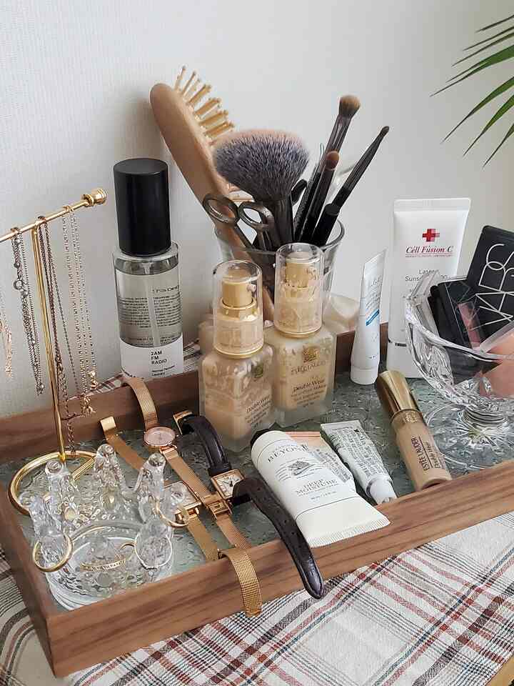 ナチュラルなブラウンの木製トレイに化粧品とアクセサリーが整頓された化粧台の小物スペース