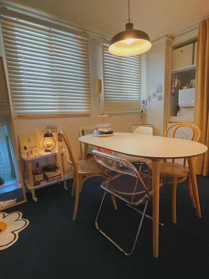 白と木目調のダイニングルーム、複数のダイニングチェアとコーヒーテーブルが配された雰囲気のあるカフェ風インテリア