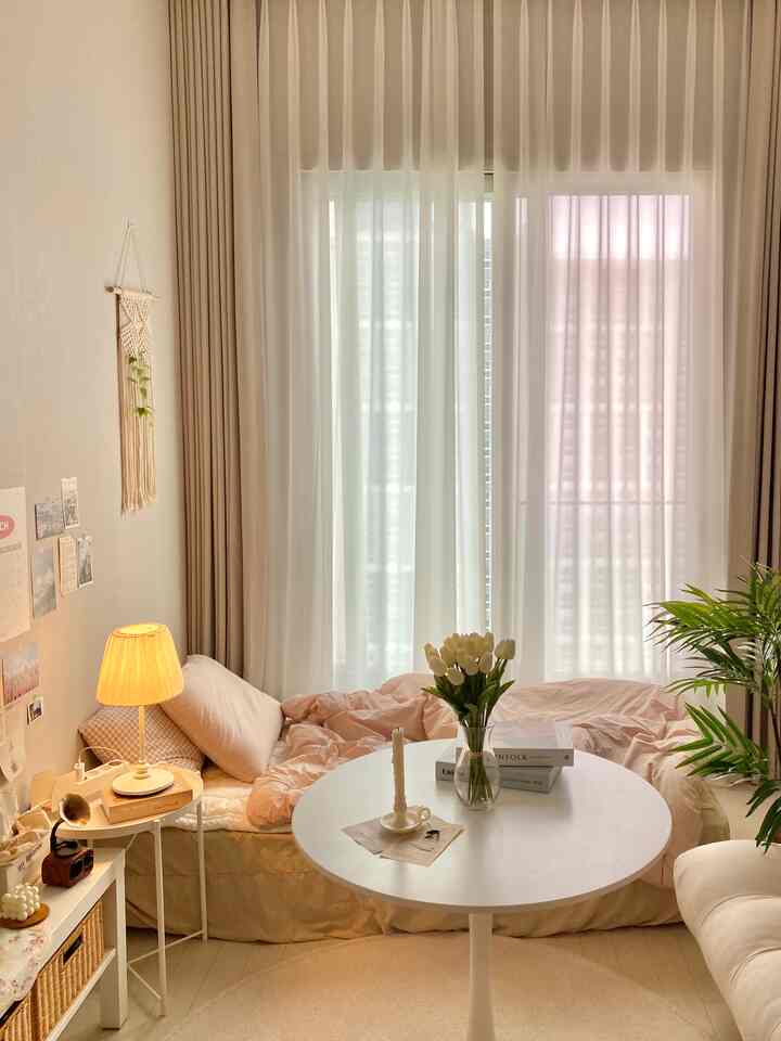 ベージュとホワイトの色調のリビングルーム、カーテンとソファ、円形テーブルが配置された温かみのある自然なインテリア