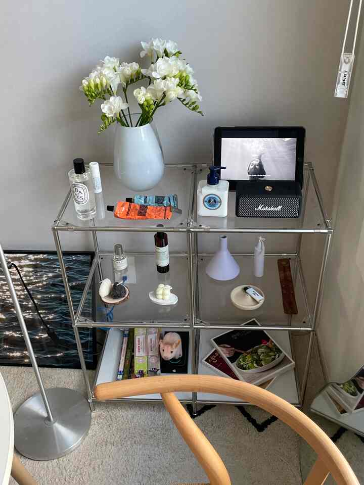 ホワイトとシルバーの色調のリビング、モジュールラッグにマーシャルのブルートゥーススピーカーとアロマスプレーが配置されたミニマルな空間