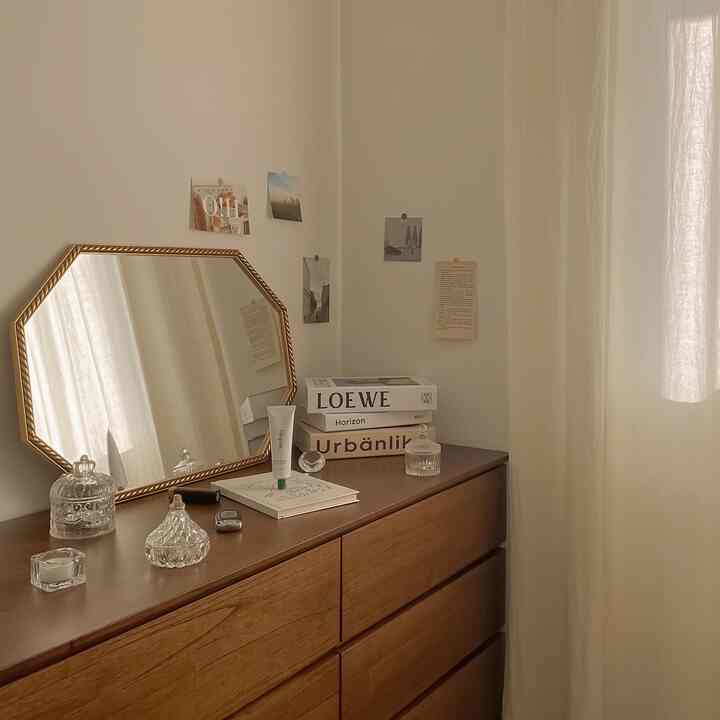 柔らかなベージュトーンのドレッサールーム、木製のチェストと金色の額縁の鏡が配置された温かみのあるインテリア