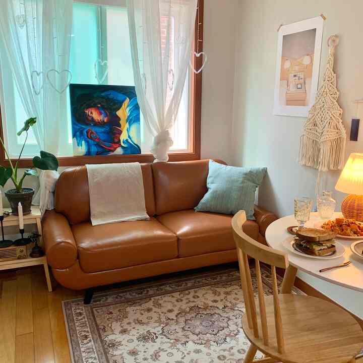 Natural vintage living room featuring camel leather sofa and wooden dining chair with soft natural light