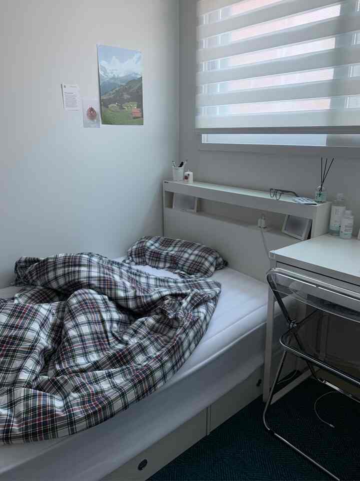 White and navy check patterned bedding in a compact single household bedroom, simple and modern atmosphere