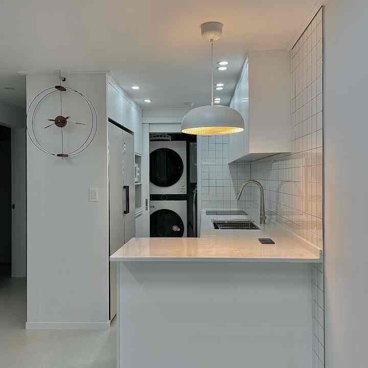 ホワイトとベージュのトーンの二人暮らしのキッチン、間仕切りとオブジェ家電が配置された清潔感と広がりのある印象的な空間