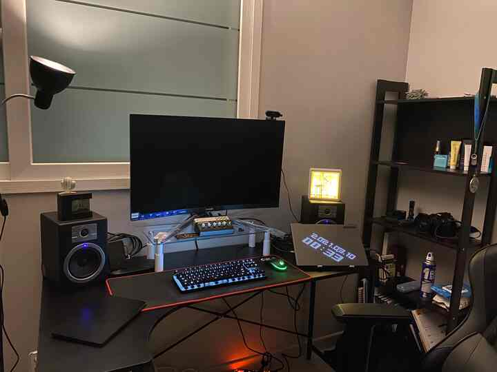 Compact home office in dark brown and black tones featuring a monitor, desk, and office chair arranged for efficient work
