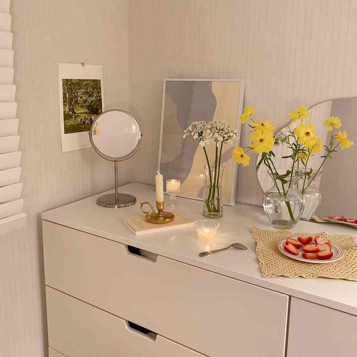 White-toned powder room with vases and posters, presenting a simple and natural ambiance