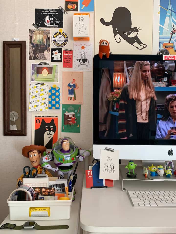 ホワイトとベージュの色調のホームオフィス、デスクの上にモニターとトイ・ストーリーのフィギュアが配置された雰囲気のある空間