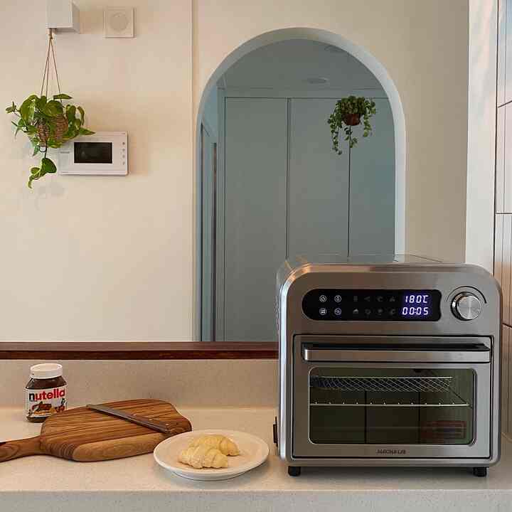 White and wood-toned kitchen space featuring an arch doorway and hanging plants with a clean, cozy atmosphere