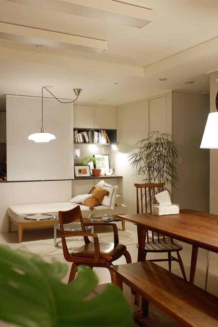 White and brown toned living room featuring wooden dining table and sofa with natural ambiance