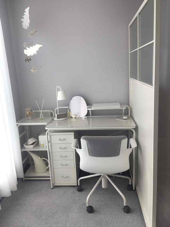 Light gray wall and white furniture create a compact home office space, highlighted with a mobile and room divider for a clean interior