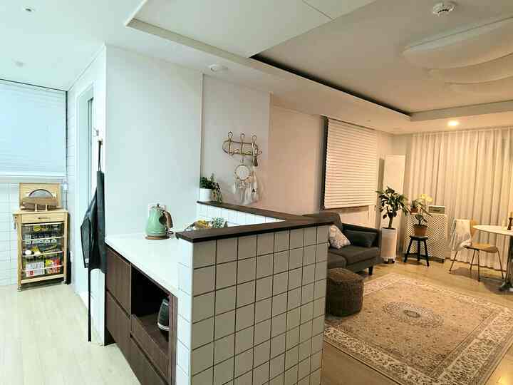 白と茶色の間仕切りで区切られたキッチンとリビング、シンプルで清潔感のあるインテリア