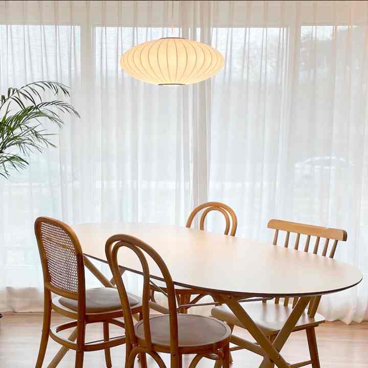 White and brown toned dining room featuring rattan and wooden dining chairs with a natural atmosphere