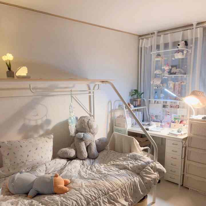 白とベージュの色調の寝室、収納ベッドとデスク、居心地の良い照明が配置された印象的な空間