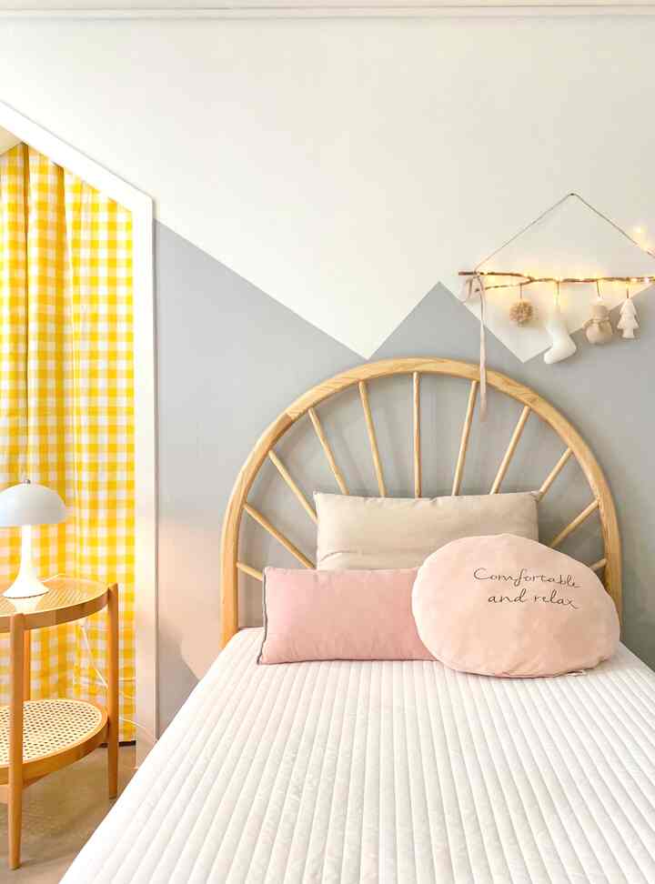 Natural toned kids' room featuring a rattan bed frame and yellow check curtains with a cozy atmosphere