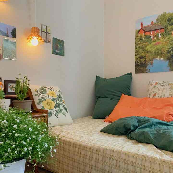 Beige and green toned bedroom featuring vintage bedding and multiple posters creating a cozy atmosphere
