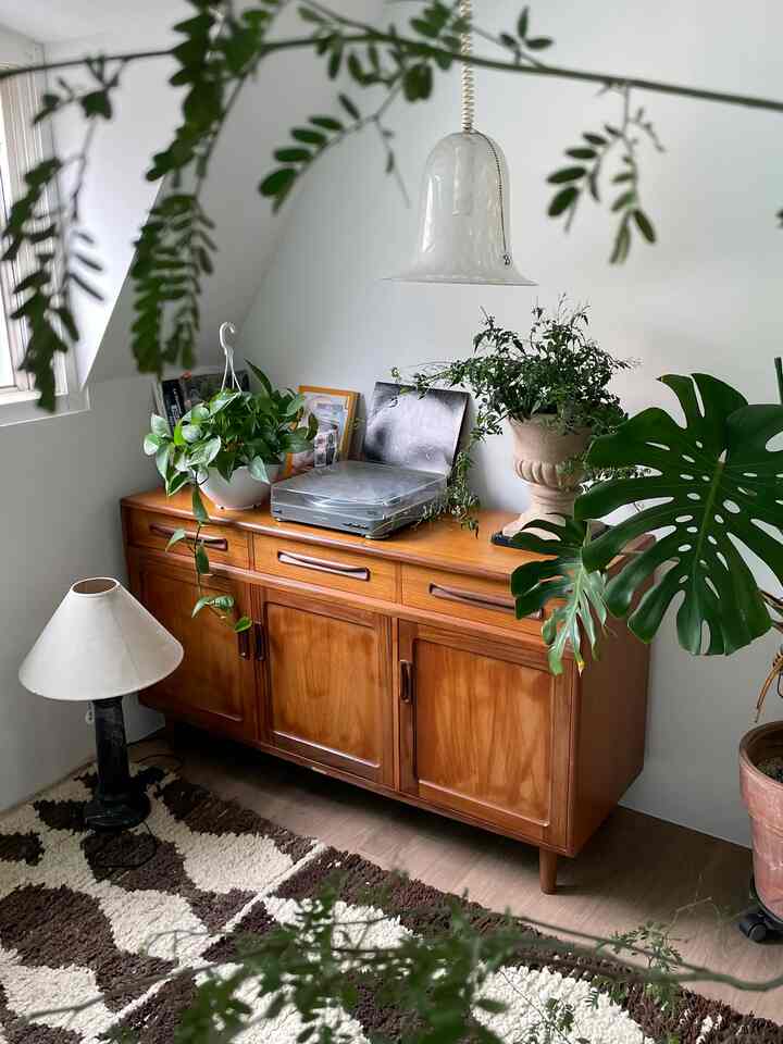 A natural wood tone workspace featuring green plants and a modern minimalist ambiance