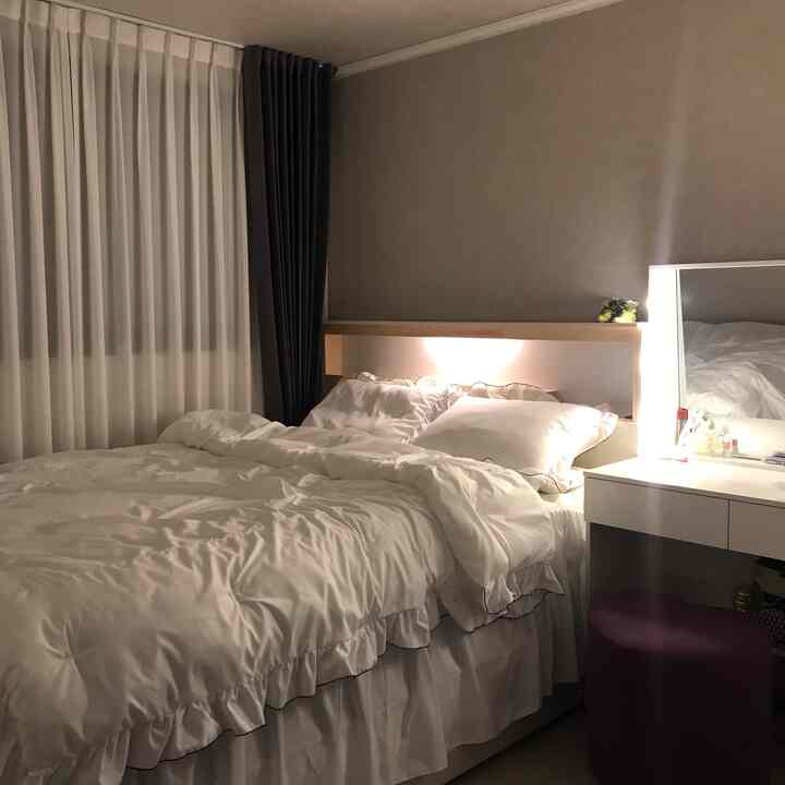 White and wood tone bedroom featuring a spacious bed and vanity with a cozy atmosphere