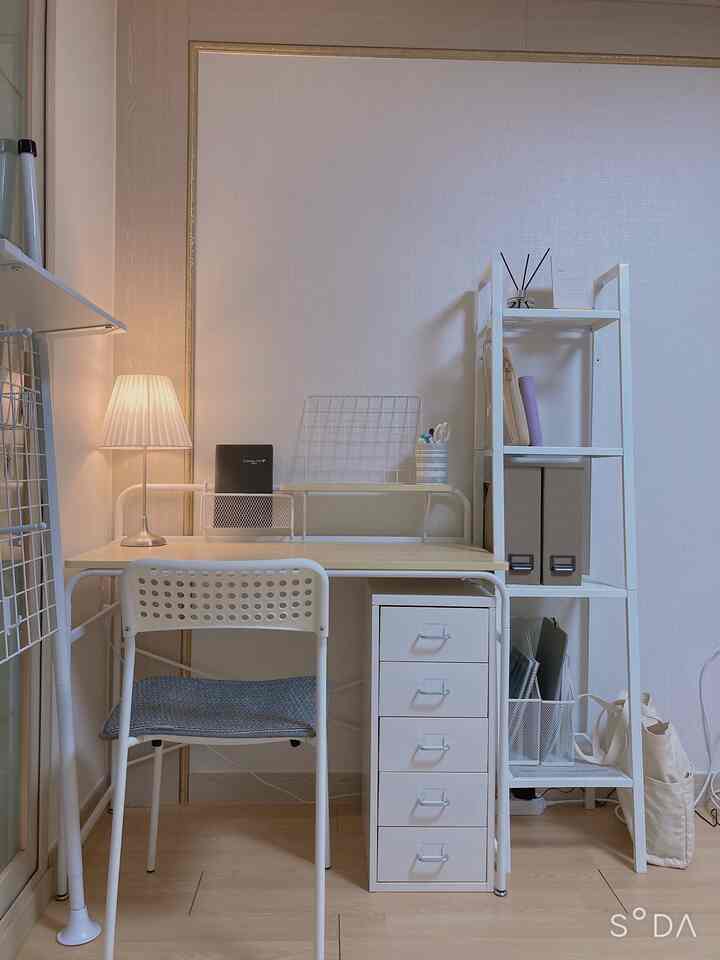 White and natural tone home office featuring a simple desk, chair, and storage units with a clean atmosphere