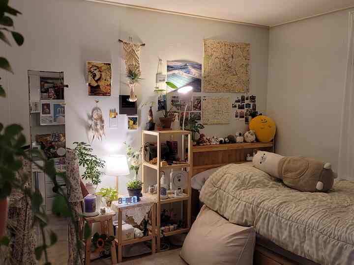 ナチュラルなトーンの寝室、木製の棚とベッド、暖かい照明が配置された居心地の良い空間