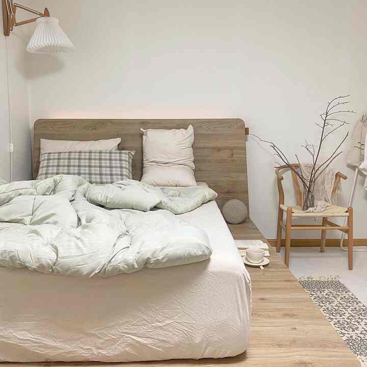 White and wood tone bedroom featuring platform bed and nightstand with simple, natural atmosphere