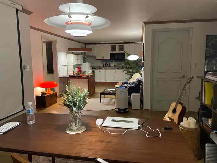 Wood tone and white living room and kitchen open space featuring pendant lighting and a coffee bar, creating a cozy and modern interior