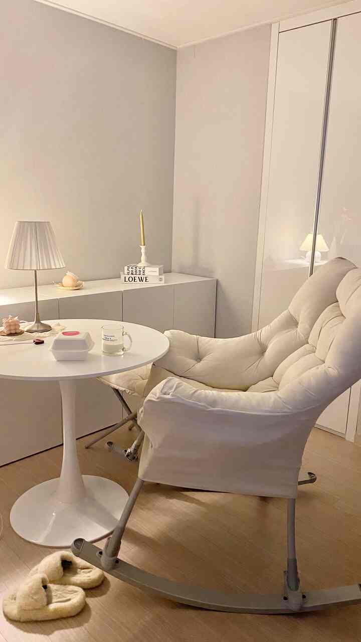 白とナチュラルトーンのリビング、快適なアームチェアとテーブルランプが配置された雰囲気のあるインテリア