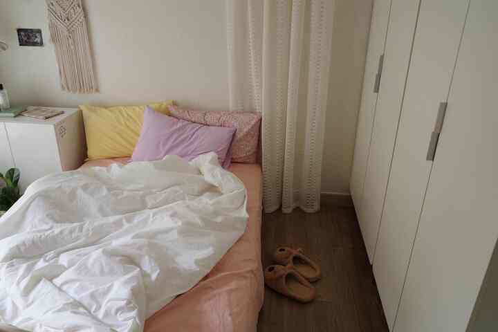 白とナチュラルカラーの調和が取れた寝室、すっきりとした収納が配置された落ち着いた空間