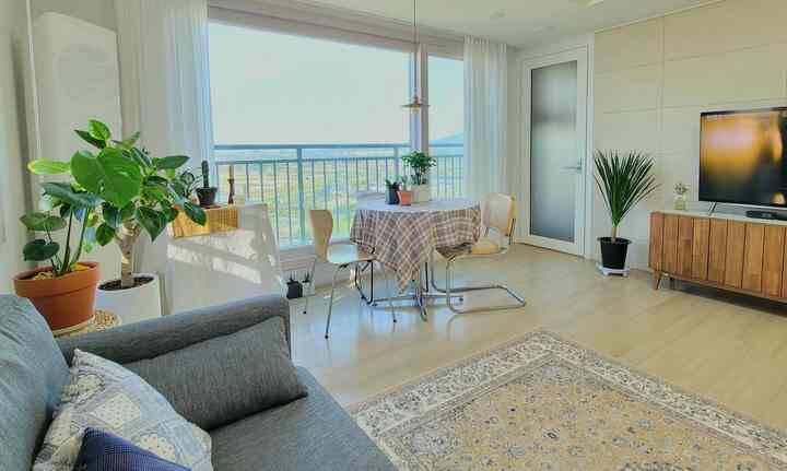 Bright natural toned living room featuring a round dining table and Persian rug with clean and cozy atmosphere