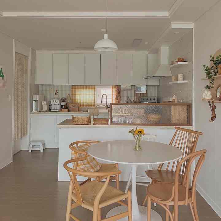 Cozy kitchen with white and wood tones featuring a round dining table, simple natural interior