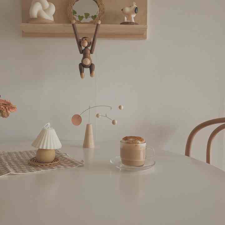 Beige and natural tone round table with coffee and mobile creating a cozy home cafe space