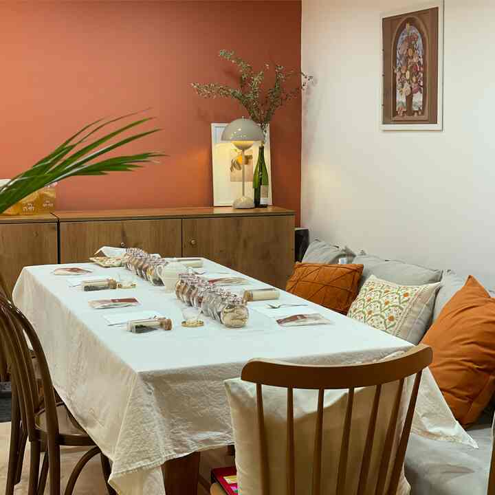 Brown and white toned dining room with wooden furniture, lighting, and cushions creating a cozy atmosphere