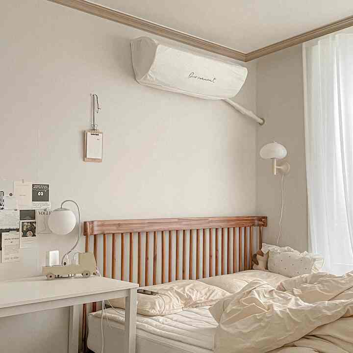 Soft white and wood-toned bedroom featuring a neat wooden bed and sheer curtains, creating a calm atmosphere