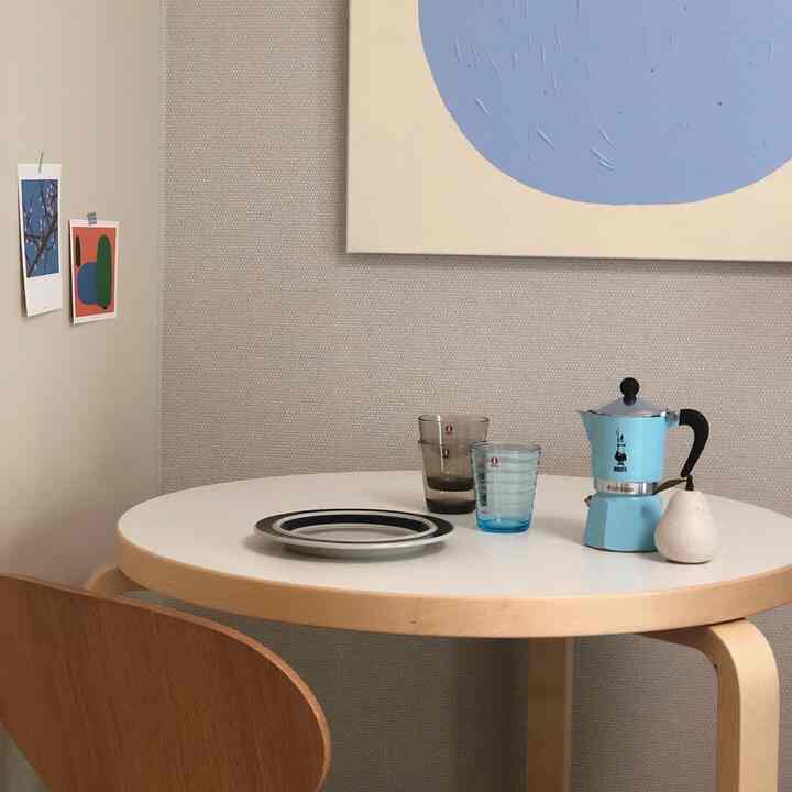 Simple single household home cafe space with blue and wood tone round table and chair setup