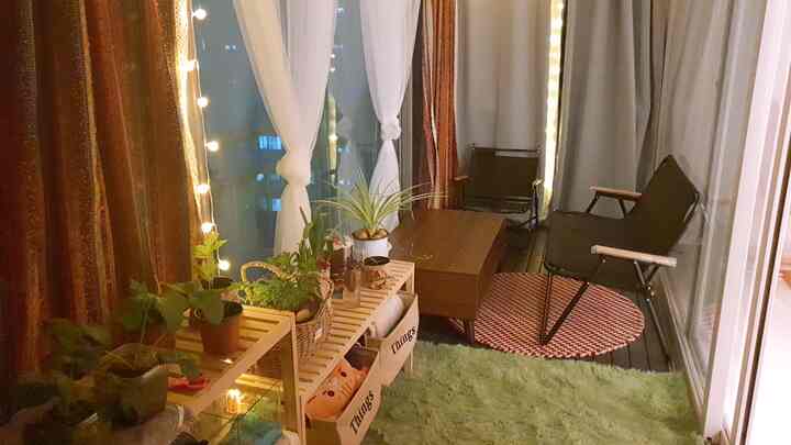 ナチュラルな木目調と緑が調和したベランダ、キャンピングチェアと植物が配置された雰囲気のある休憩空間