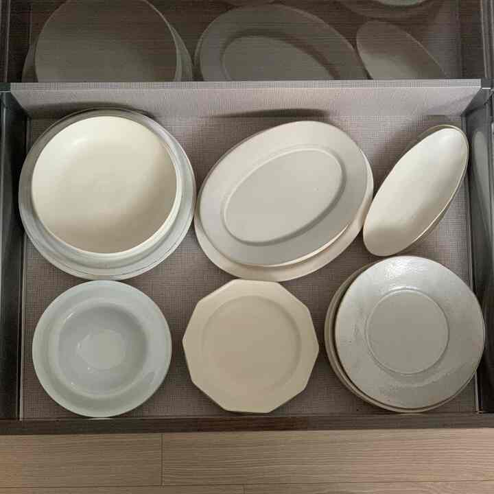 明るいアイボリーと白のトーンのキッチン引き出しに整理された皿