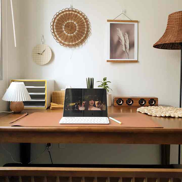 Natural wood tone and beige home office featuring a desk with iPad and lighting in a minimalistic setting
