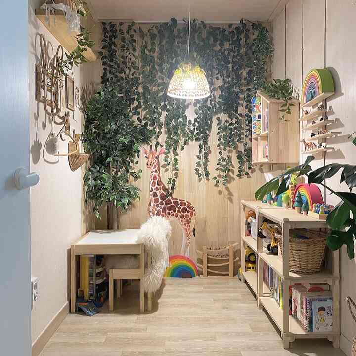 Natural wood-toned kids' room featuring giraffe wall sticker and artificial plants with cozy atmosphere