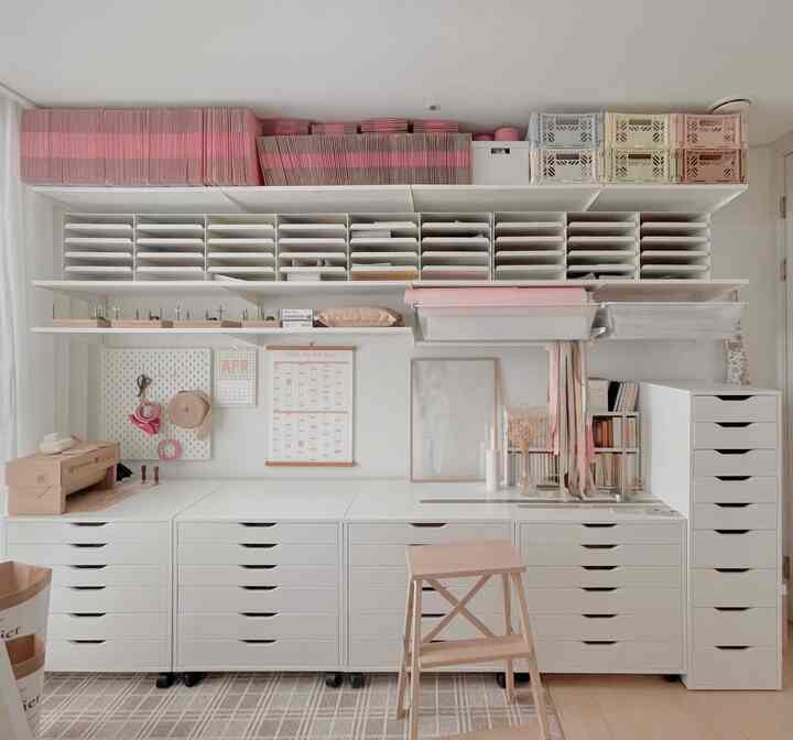白とパステル色調の整理されたホームオフィス、棚やチェストを使った収納アイデアが活かされたシンプルなインテリア