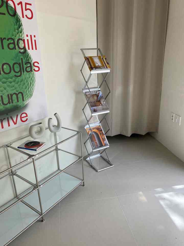 Natural toned small space featuring stainless steel shelves, beige curtains, and minimalistic decor creating a clean interior