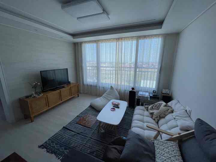 Living room in white and beige tones featuring a navy rug and bean bag sofa for a cozy atmosphere