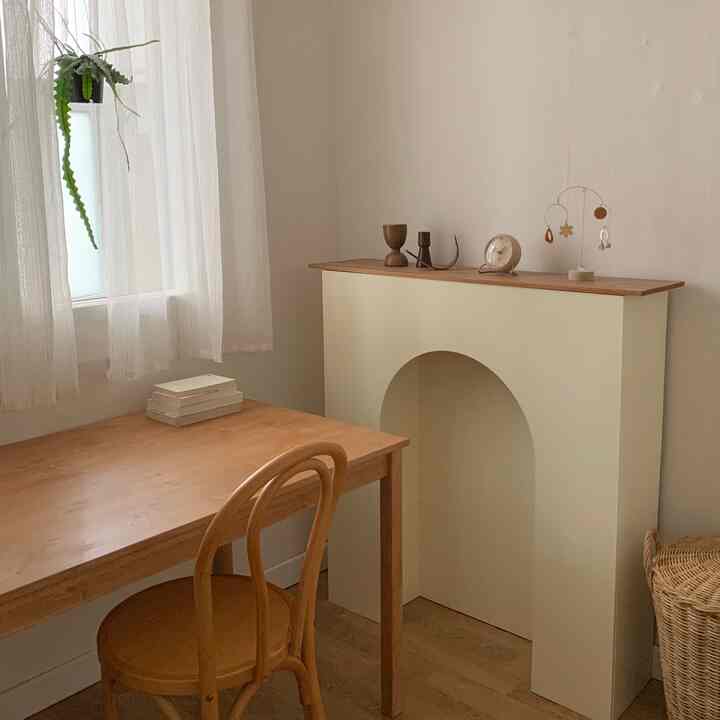 Small room with natural colors featuring a wooden desk and a console, creating a simple and warm atmosphere