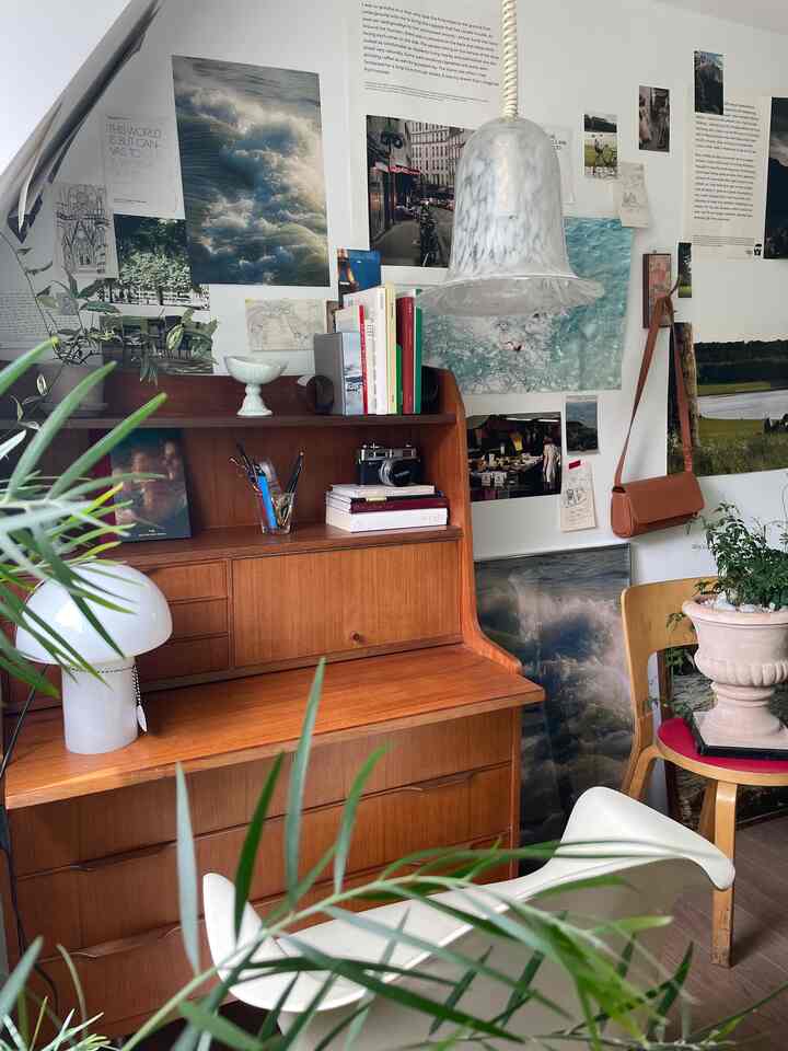 Natural toned living room featuring wood tone furniture and various posters decorating the wall