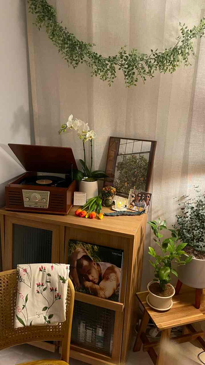 ナチュラルな木の家具と多様な植物が配置されたヴィンテージ感のある落ち着いたインテリア