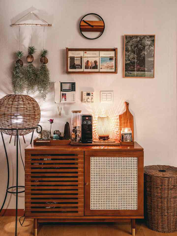 Natural wood-toned living room coffee bar space featuring macramé air plants and rattan basket, creating a cozy atmosphere