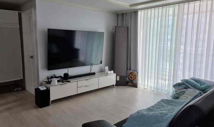 White and gray toned newlywed living room featuring large sofa and long curtains, modern and simple atmosphere