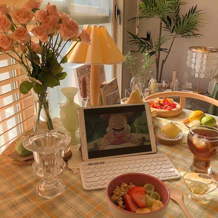 Warm yellow-toned kitchen space featuring a round table with vases, candles, and drinks in a natural decor style