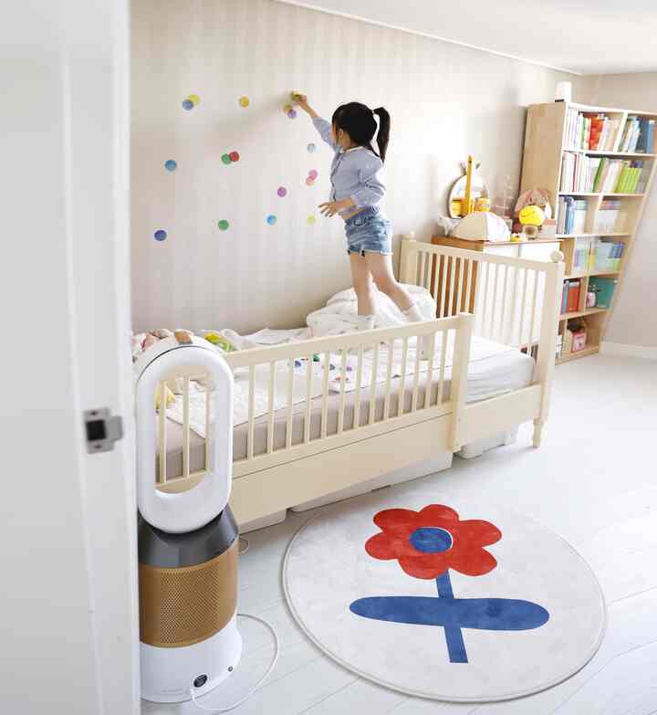 Bright kids' room in white and wood tones featuring a child's bed and bookshelf with clean, natural feel