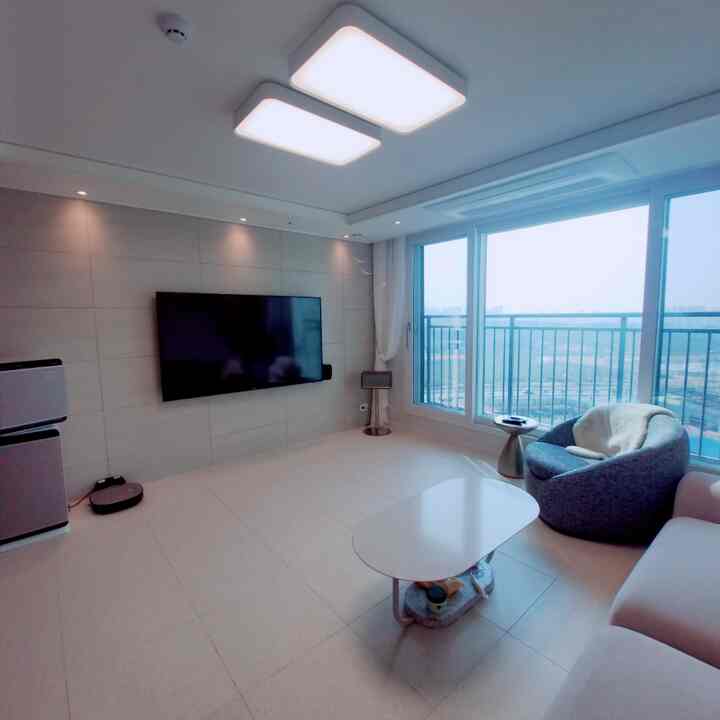 White-toned living room featuring modern sofa, armchair, and coffee table in a clean and bright space